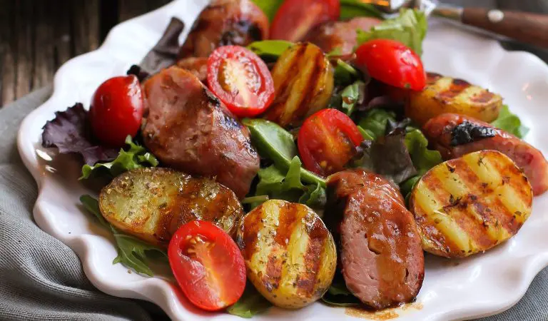 Grilled sausage, potato, and mixed green salad.
