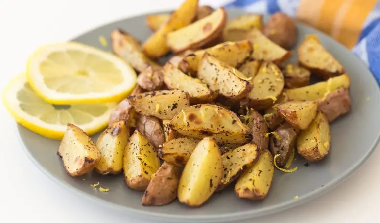 Potato wedges with lemon and pepper on a little plate.