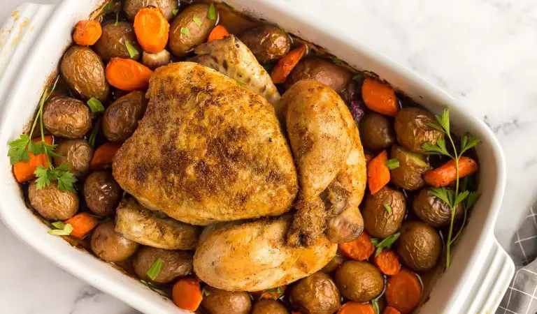 Poulet rôti avec petites pommes de terre, carottes et légumes sur une plaque