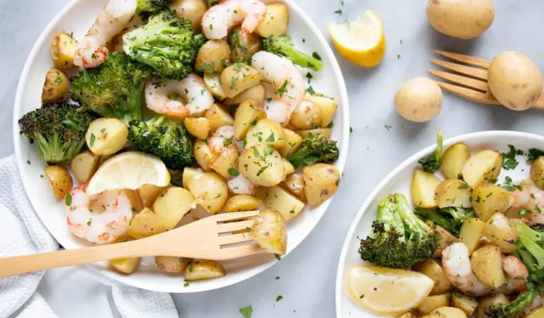 Sheet pan shrimp and potatoes in little plates with cute wooden forks.