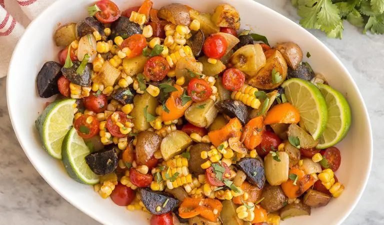 A bowl of southwest potato salad with lots of colorful veggies.