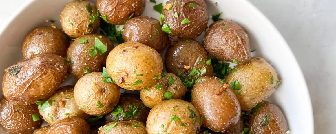 A bowl of Air Fried Little Potatoes with fresh herbs.