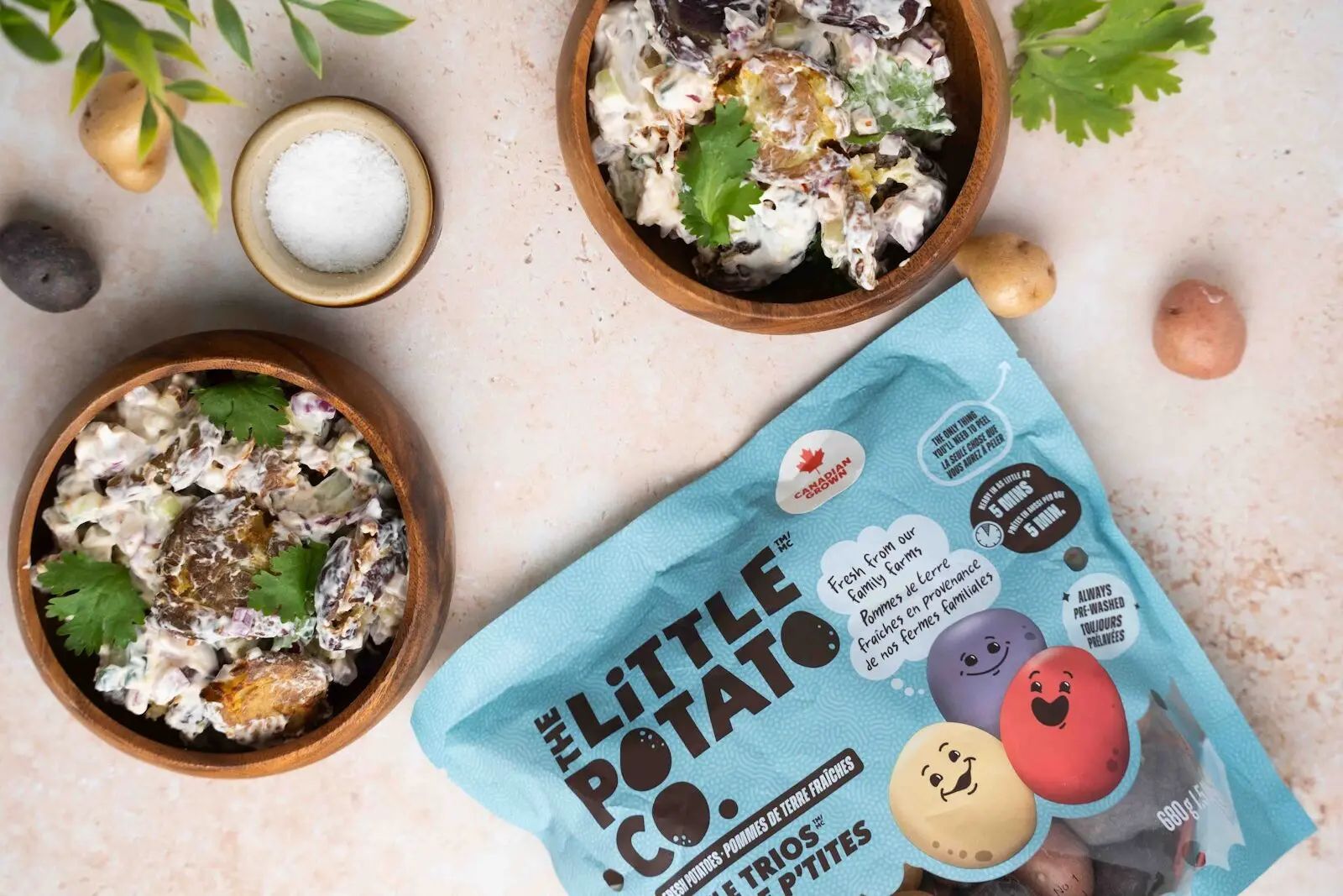 Two bowls of a smashed potato salad on a white background with a bag of Little Trios® next to them.