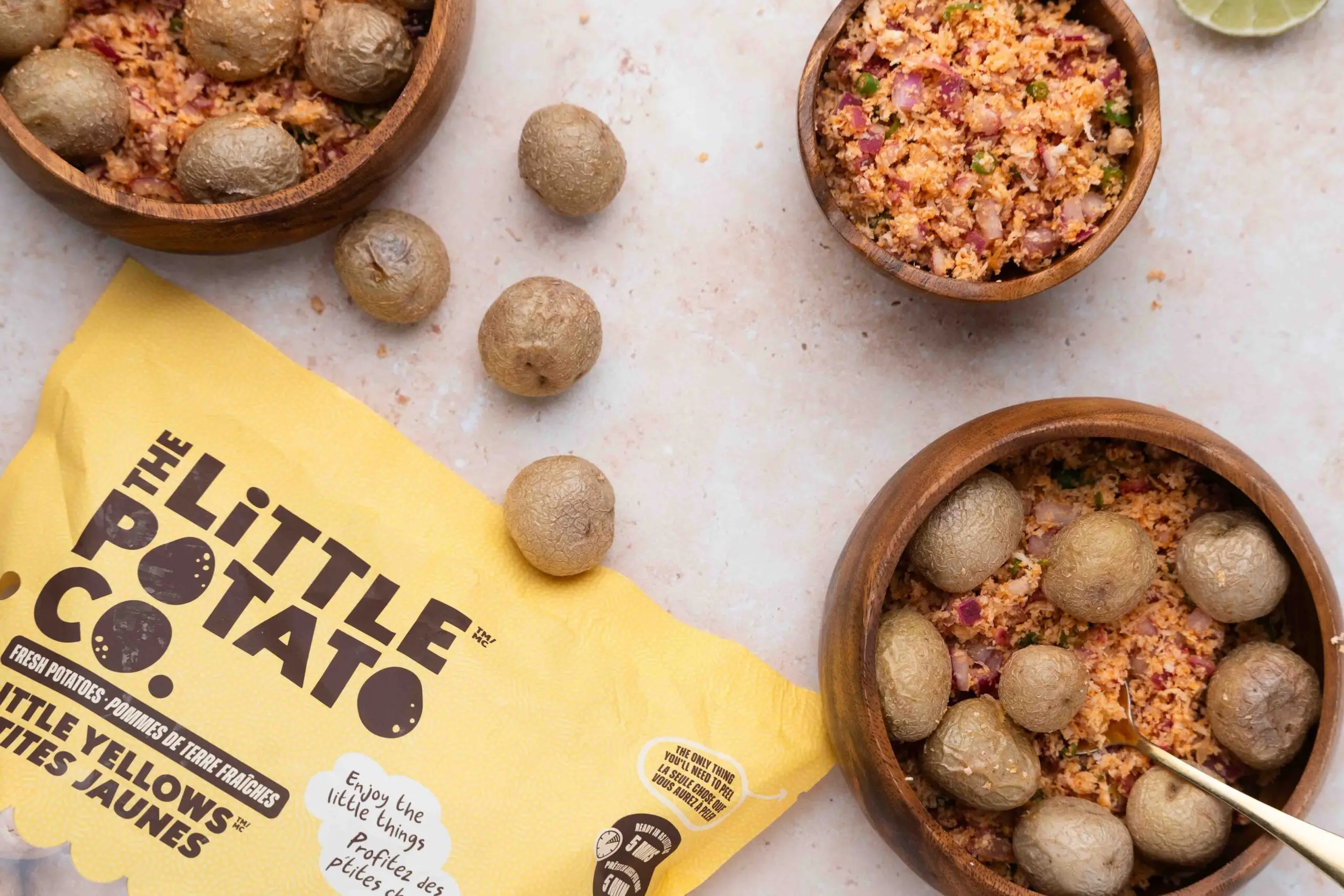 A package of Little Yellows® next to two bowls of a pol sambol inspired potato salad.