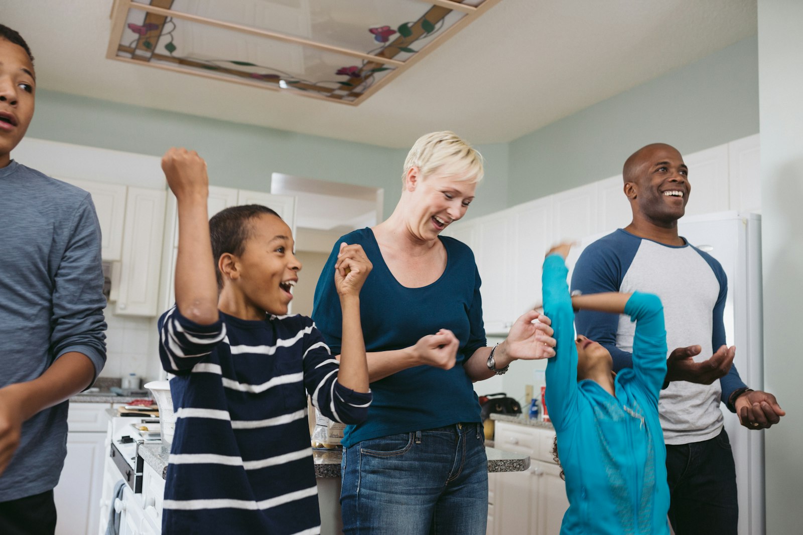 Angela and her family in their kitchen throwing potatoes around.