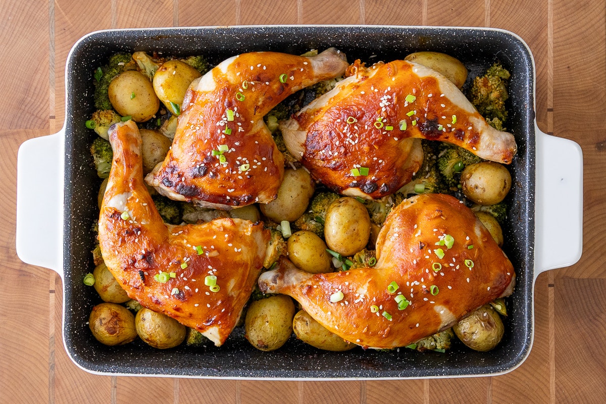 A sheet pan with Little Potatoes and chicken piled up. The chicken looks especially crispy and delicious.