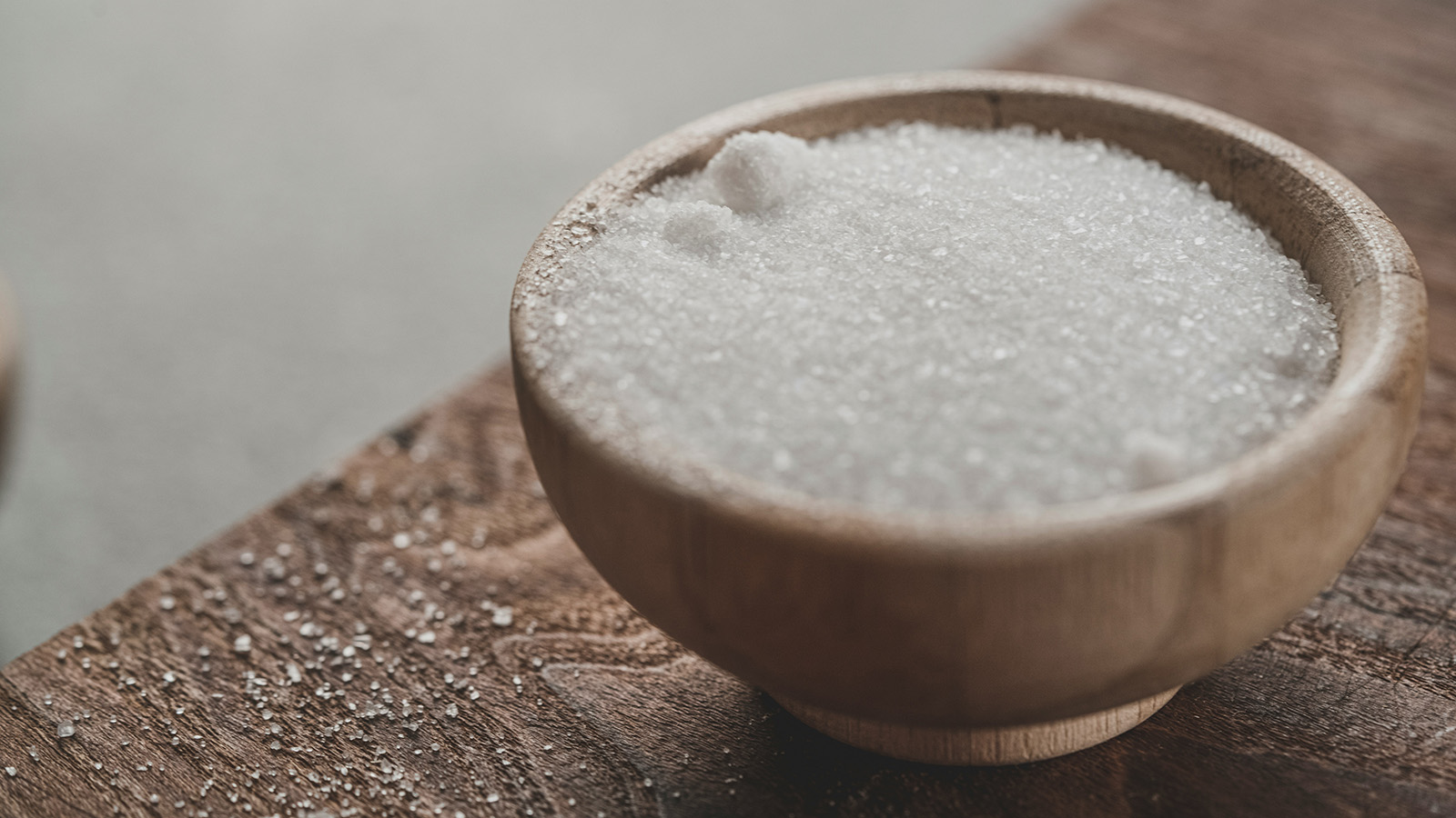 A bowl of sea salt sits on a table