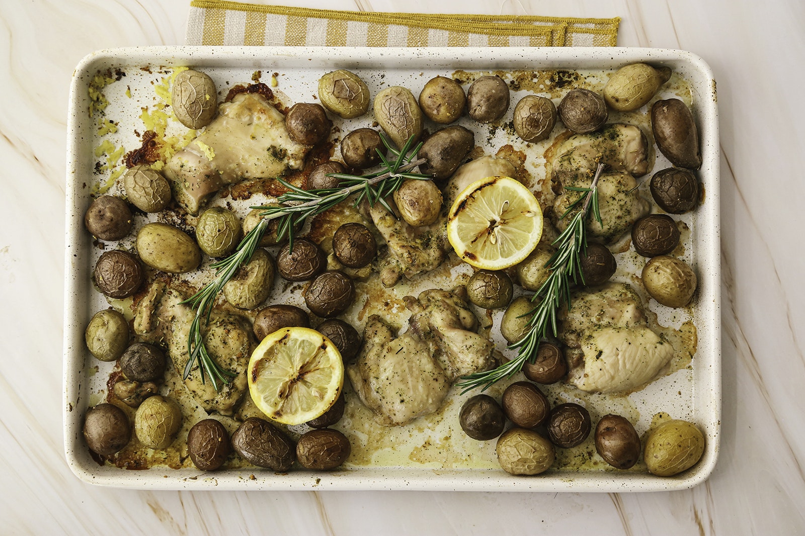 A sheet pan of Lemon and Rosemary Chicken with Little Trios™.