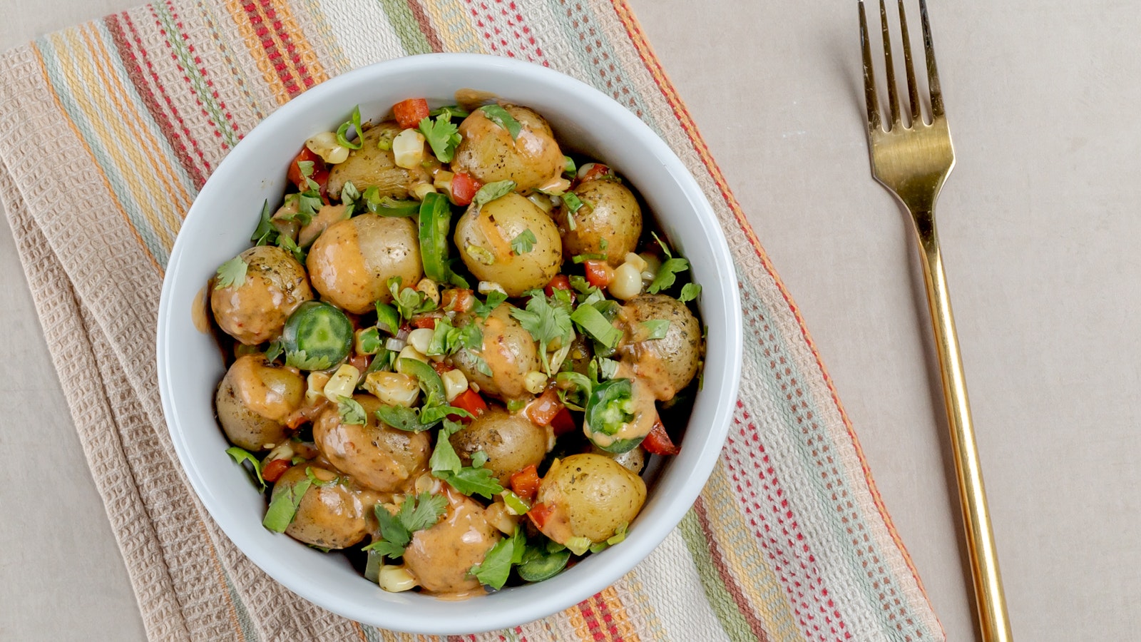 A nacho bowl with Oven or Grill Ready Little Potatoes and other fresh veggies.