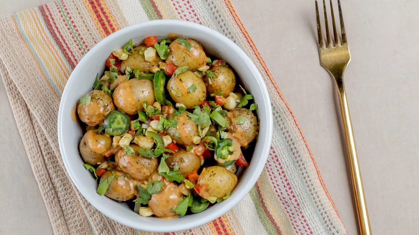 A nacho bowl with Oven or Grill Ready Little Potatoes and other fresh veggies.