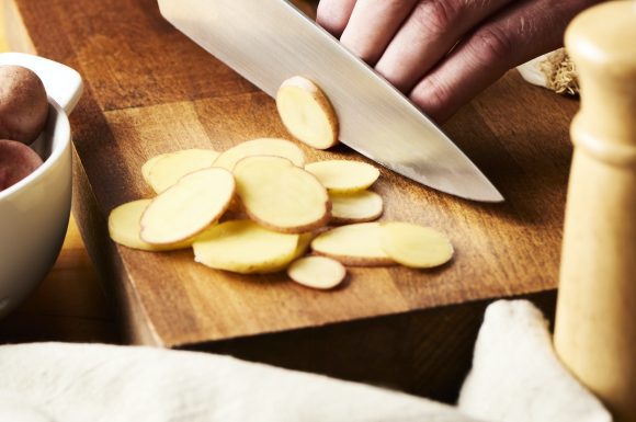 Slicing little potatoes.