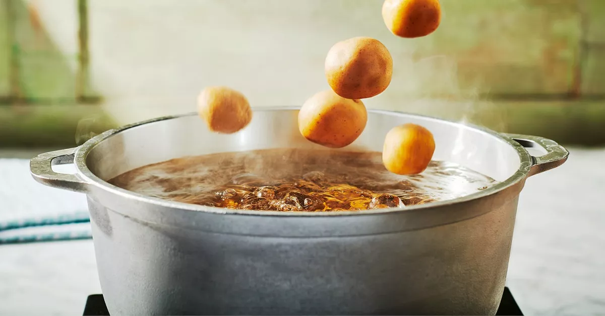 Flavorful Boiled Potatoes 3 Ways No Packaging Potatoes being tossed into a pot of boiling water.