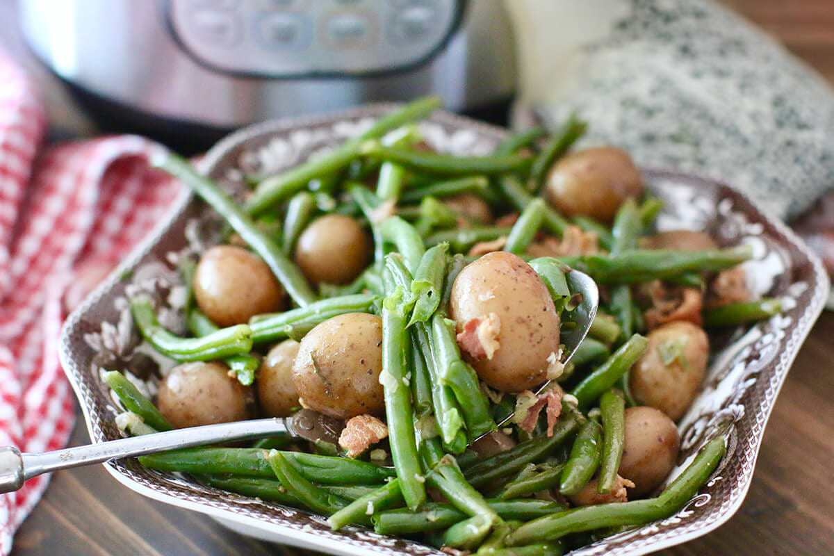 A bowl of Little Potatoes and green beans with some delicious bacon.