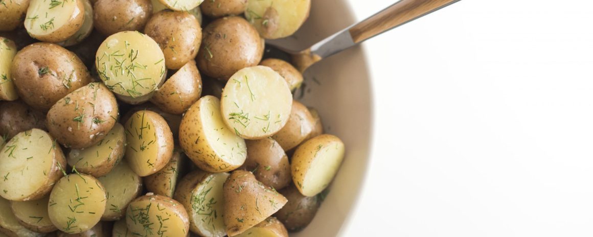 Buttered dill potatoes in a bowl.