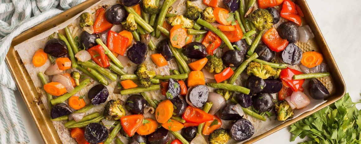 A sheet pan of easy roasted vegetables with carrots, bell peppers, broccoli, and asparagus
