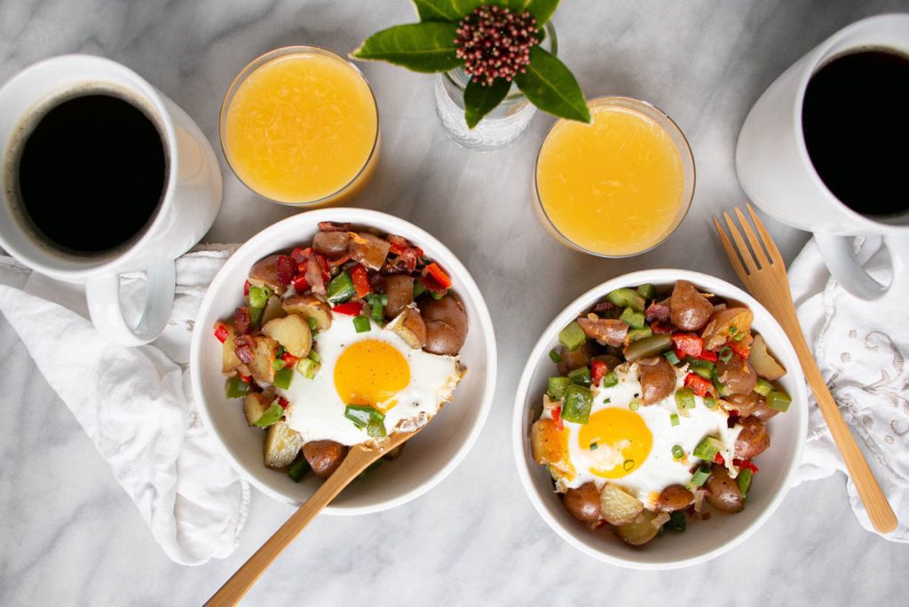 Easy skillet breakfast potatoes in bowls with some orange juice next to it.