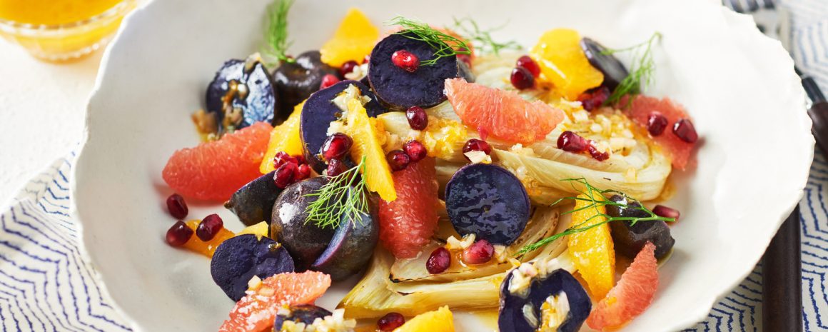 A bowl of little potatoes with fennel and colourful fruits and veggies.