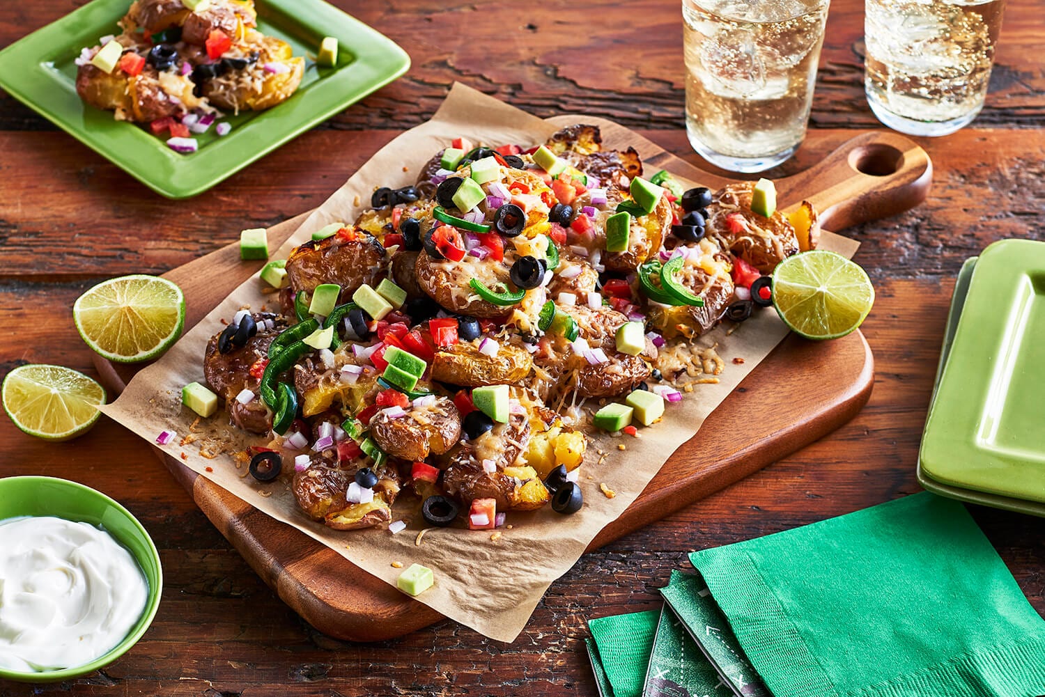 A parchment paper lined cutting board of fully loaded nachos.