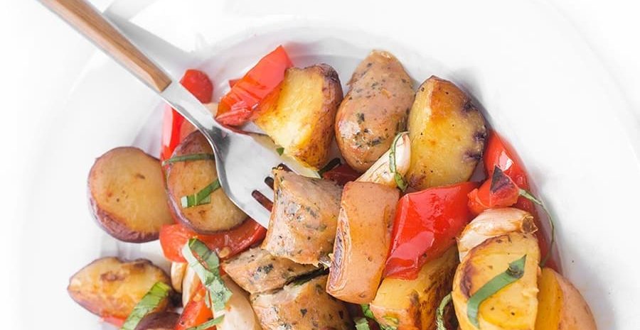 A plate of grilled sausages, peppers, and potatoes.