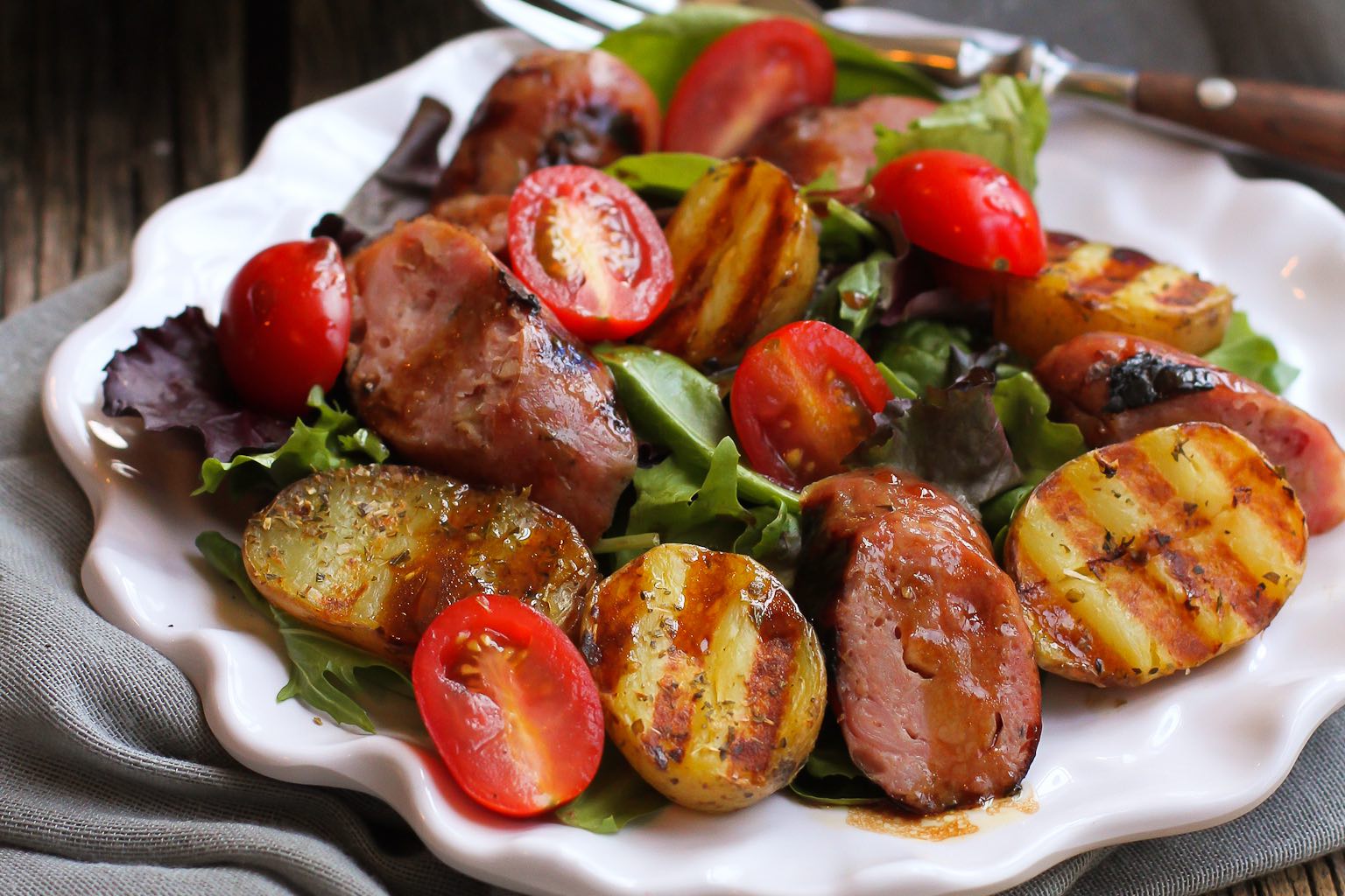 Grilled sausage, potato, and mixed green salad.