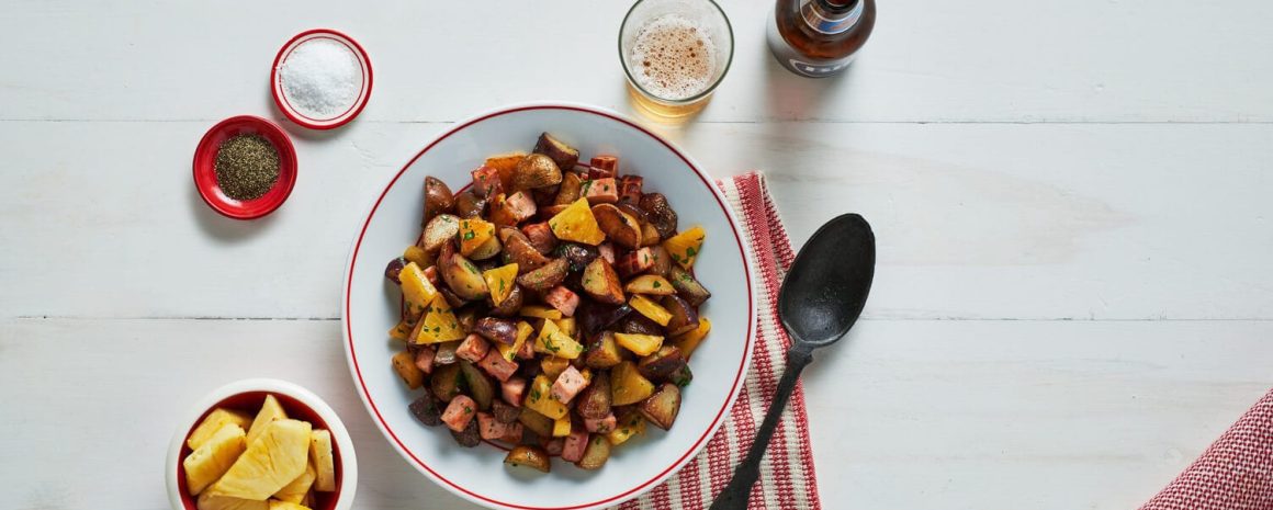 A bowl of ham and pineapple pan-fried potatoes.