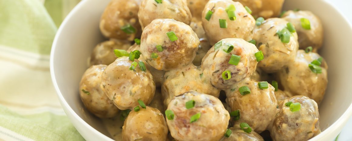 A bowl of slow cooker cheesy potatoes.