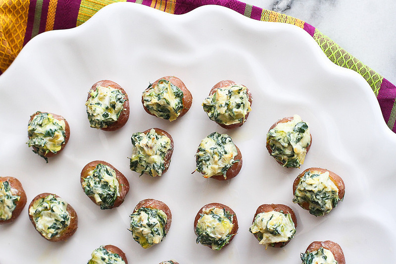 A plate of mini spinach and artichoke stuffed potatoes.