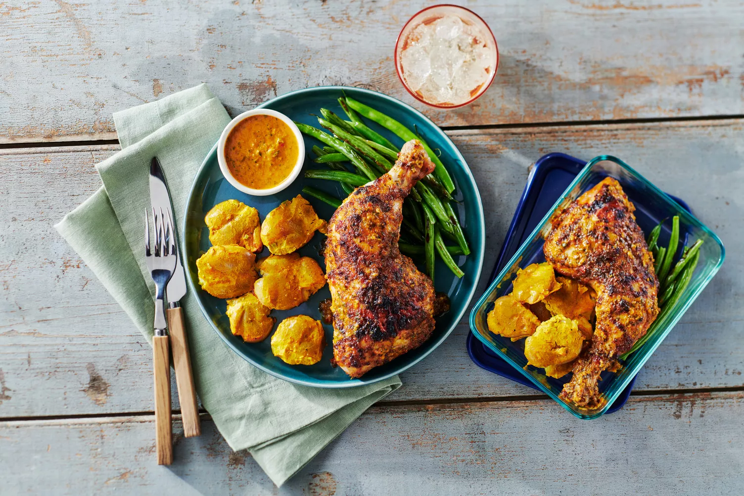 A plate of piri piri chicken and green beans with little potatoes.