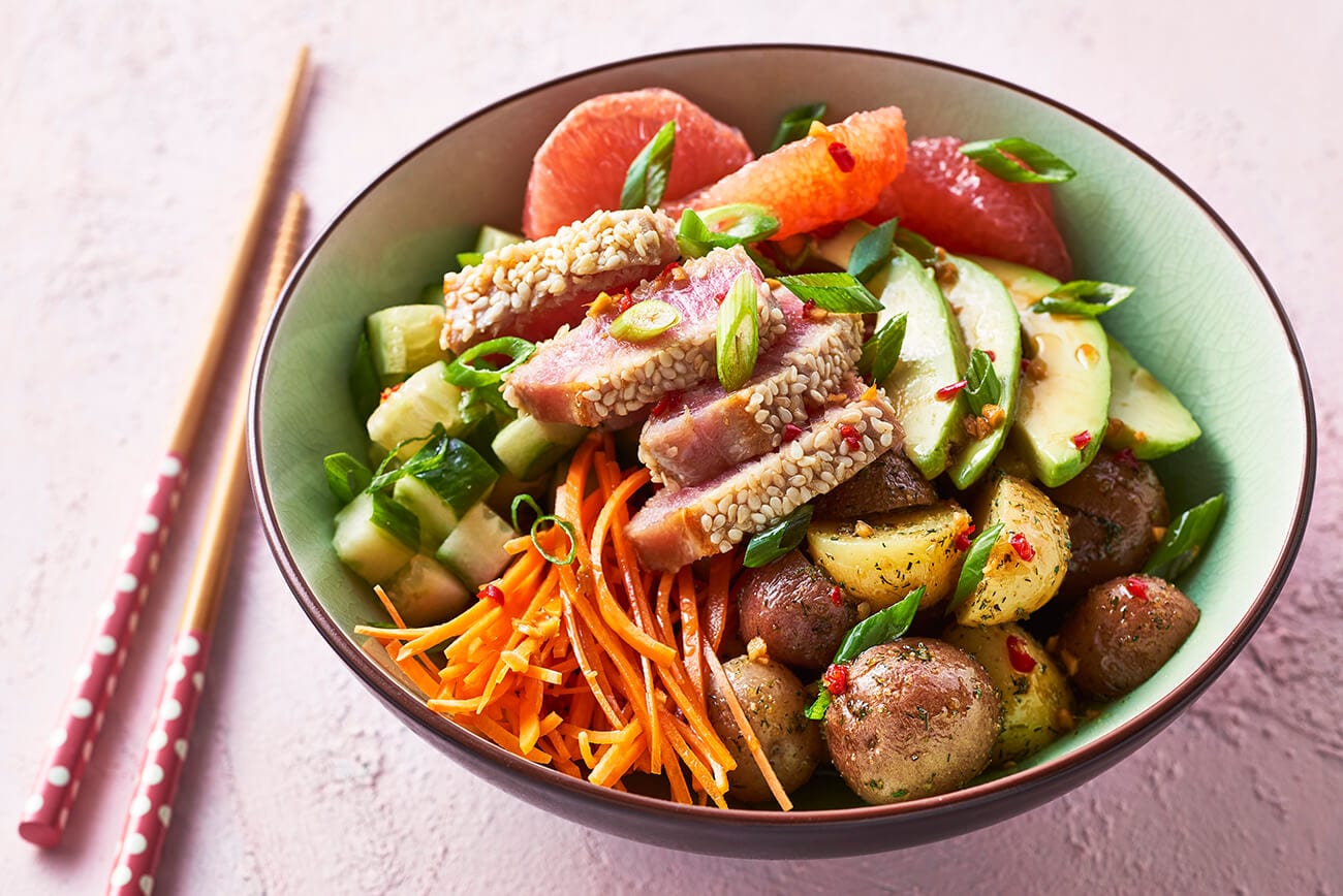 A poke bowl made with potatoes and tuna with avocado and other delicious fresh veggies.