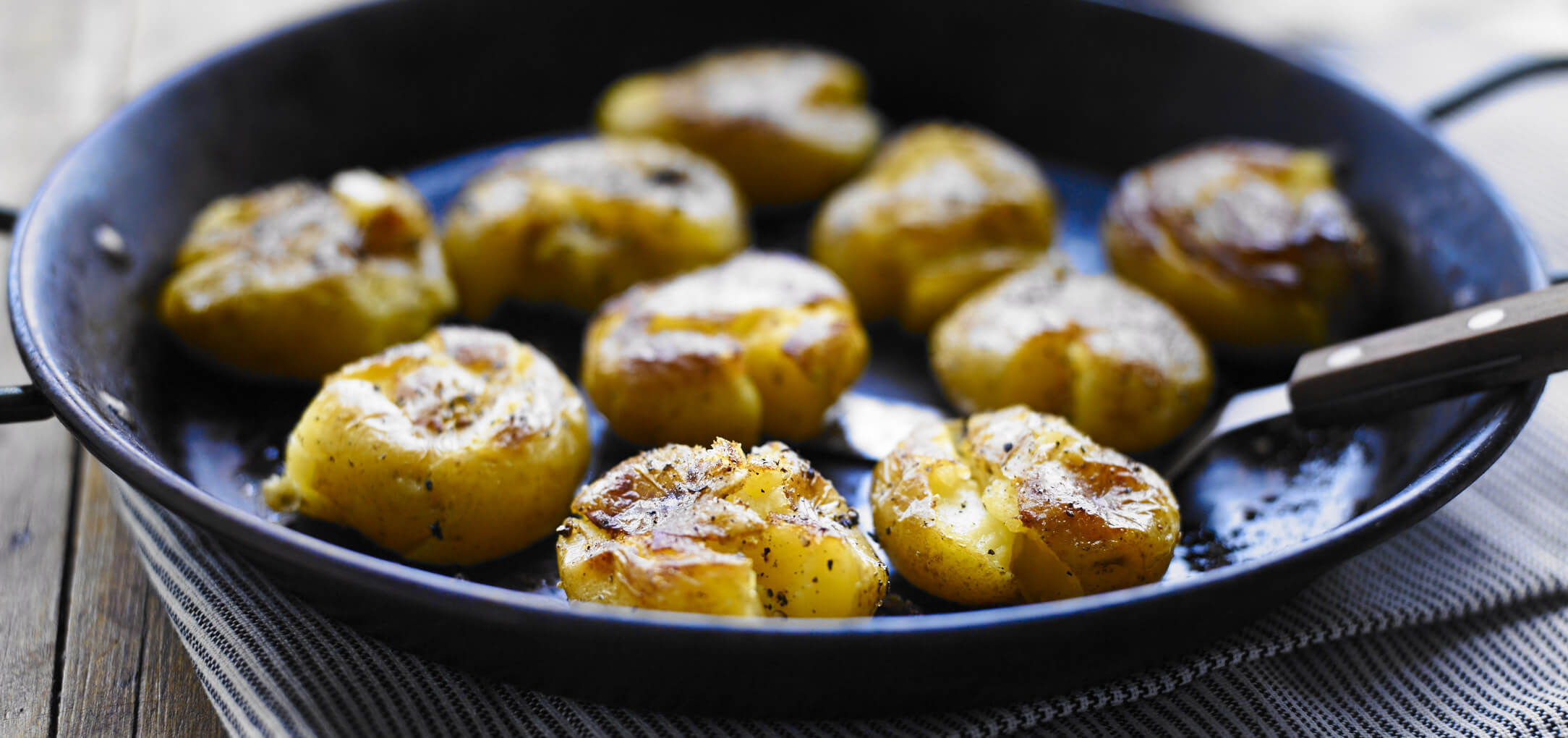 Simply smashing potatoes in a cast-iron skillet.