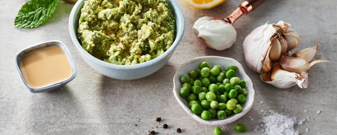 A bowl of green peas and mint dip to serve with smashed potatoes.