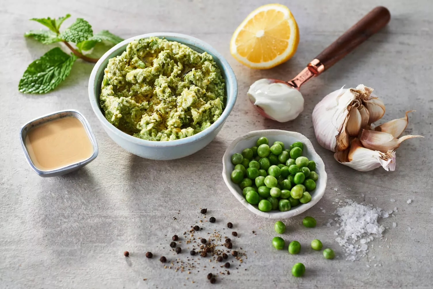 A bowl of green peas and mint dip to serve with smashed potatoes.