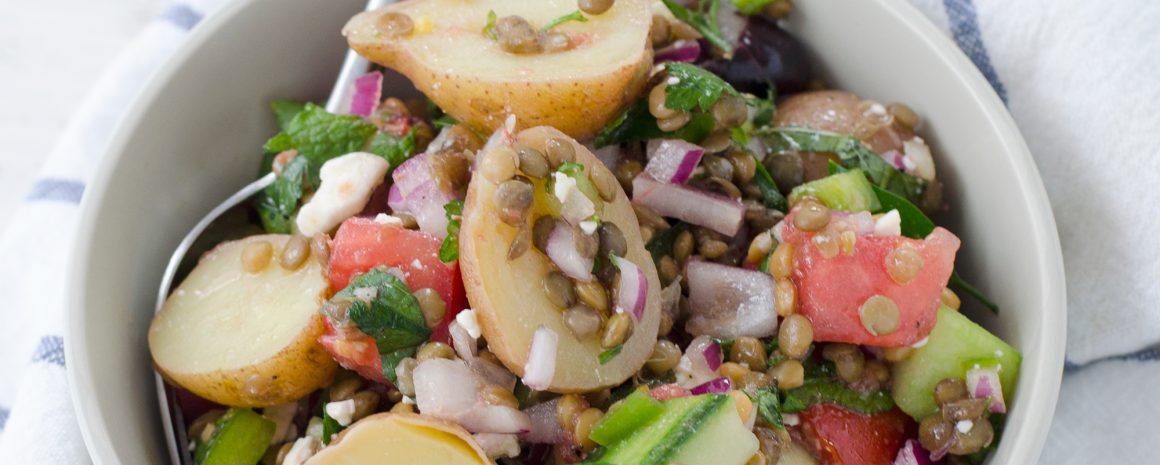 A bowl of Greek salad and lentils.