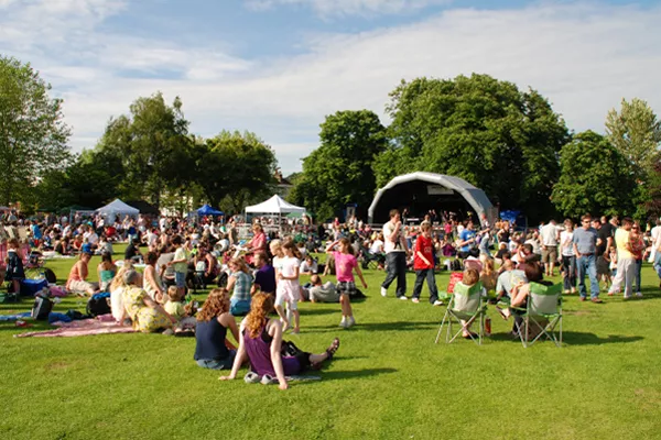 A group of people hosting a community event outside on the grass.