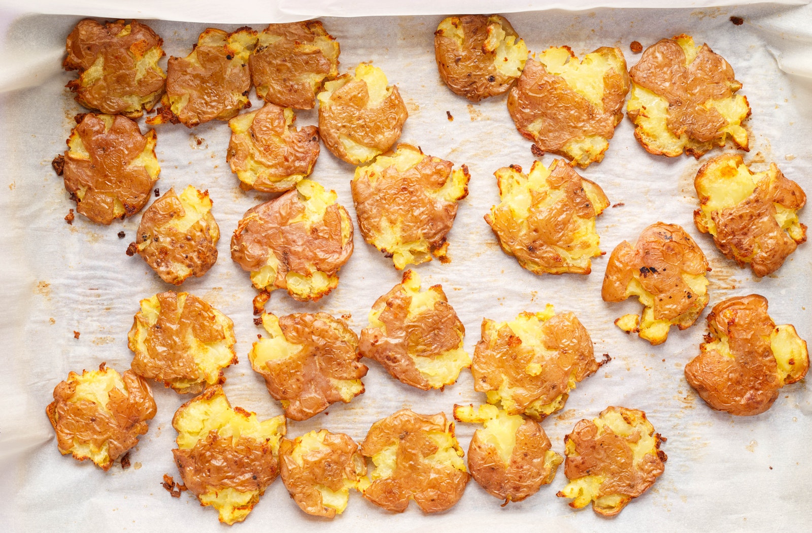 Smashed potatoes on a baking sheet.