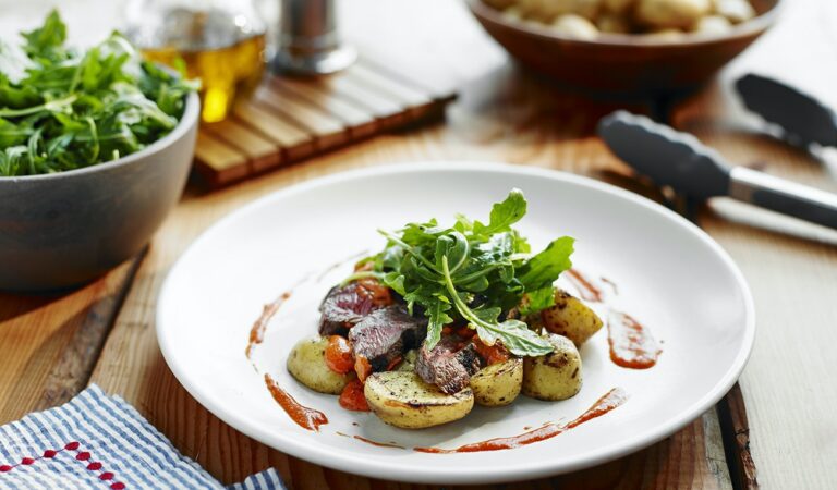 A plate of steak and Little Potatoes with Romesco sauce.