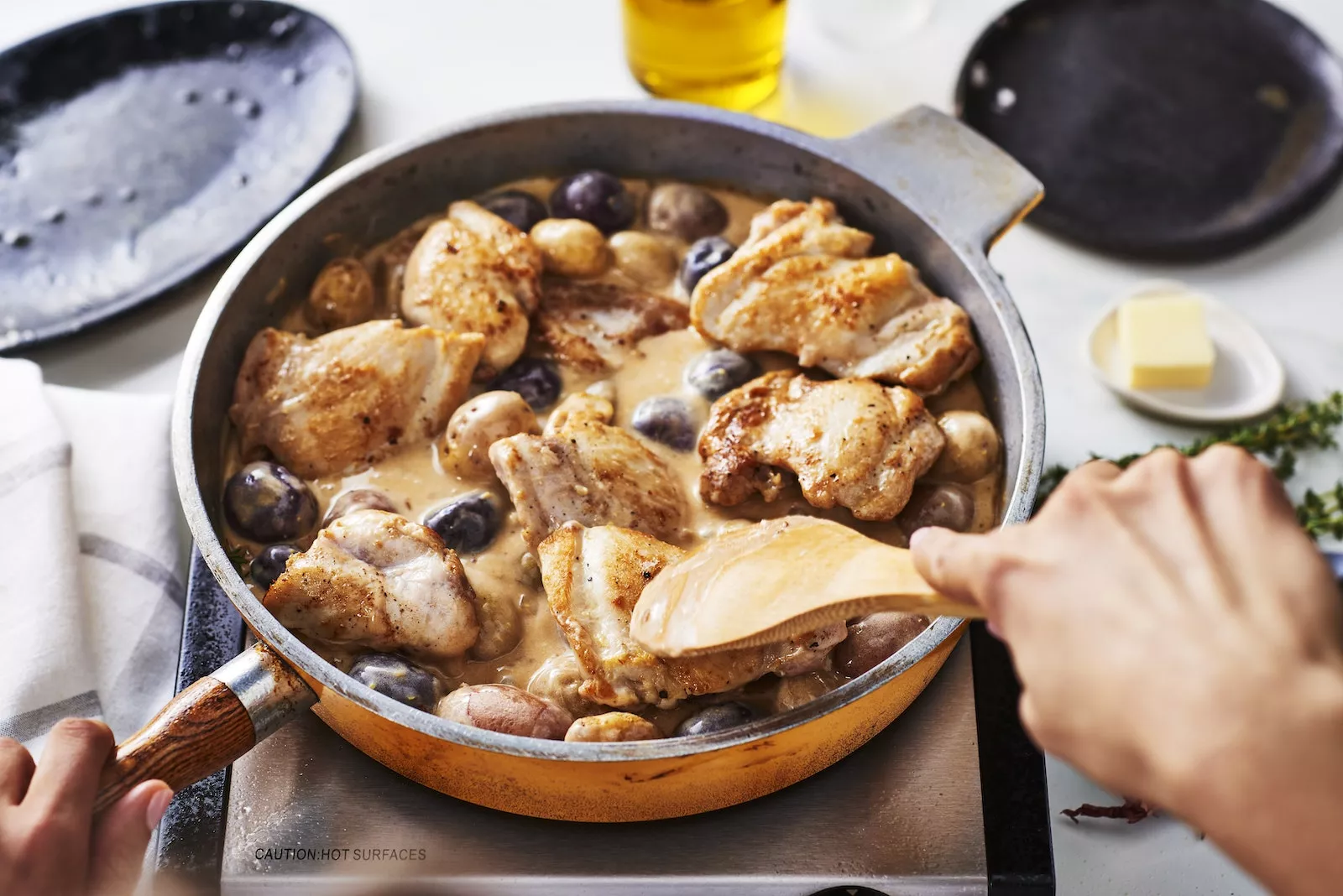 A pan with chicken and potatoes in it.