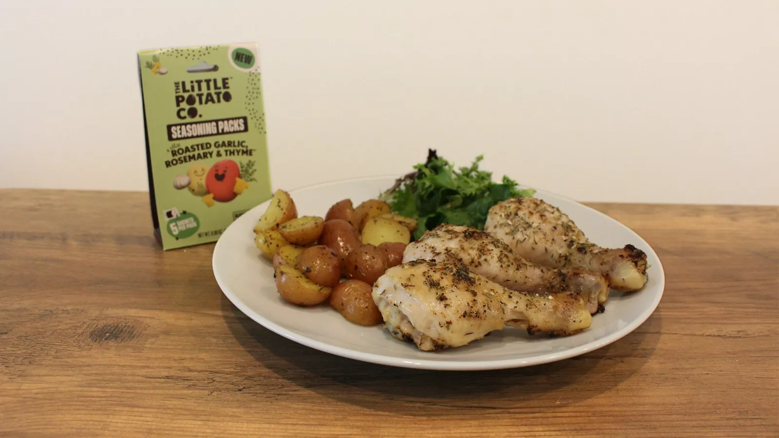A sheet pan lemon and rosemary chicken with a carton of our seasoning packs in the background.