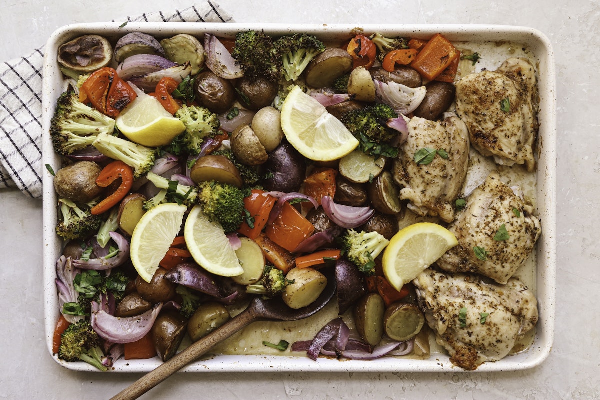 A tray of chicken and veggies like Little Potatoes on a sheet pan.