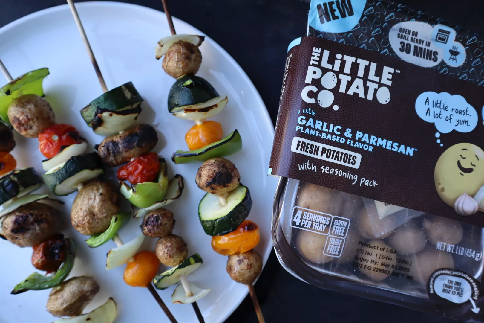 Garlic Parmesan Potato and Veggie Skewers A plate of veggie skewers on a plate with a package of our A Little Garlic & Parmesan™ Oven or Grill Ready Little Potatoes