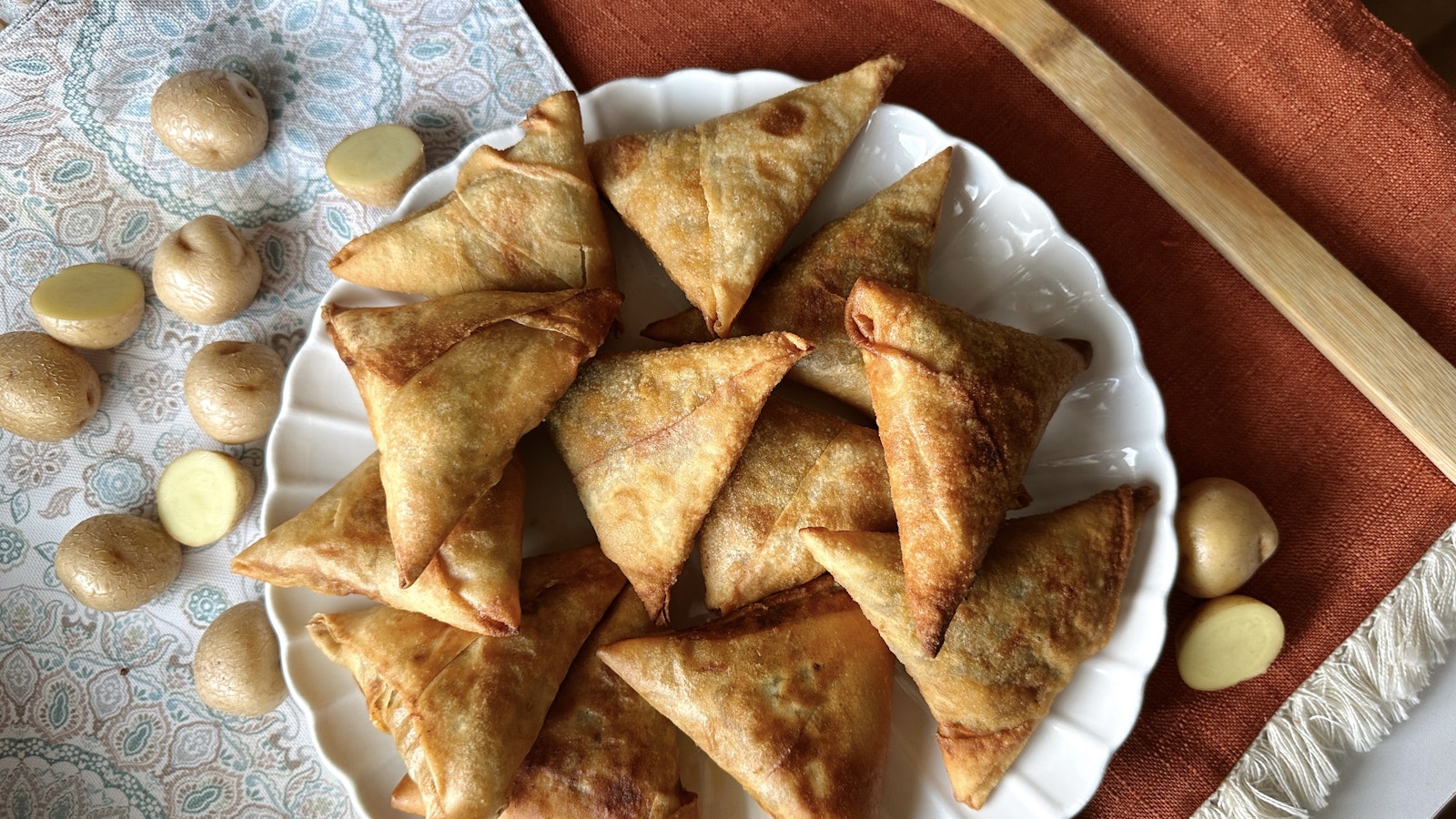 A delicious looking plate of samosas made with Little Potatoes sit on a table.