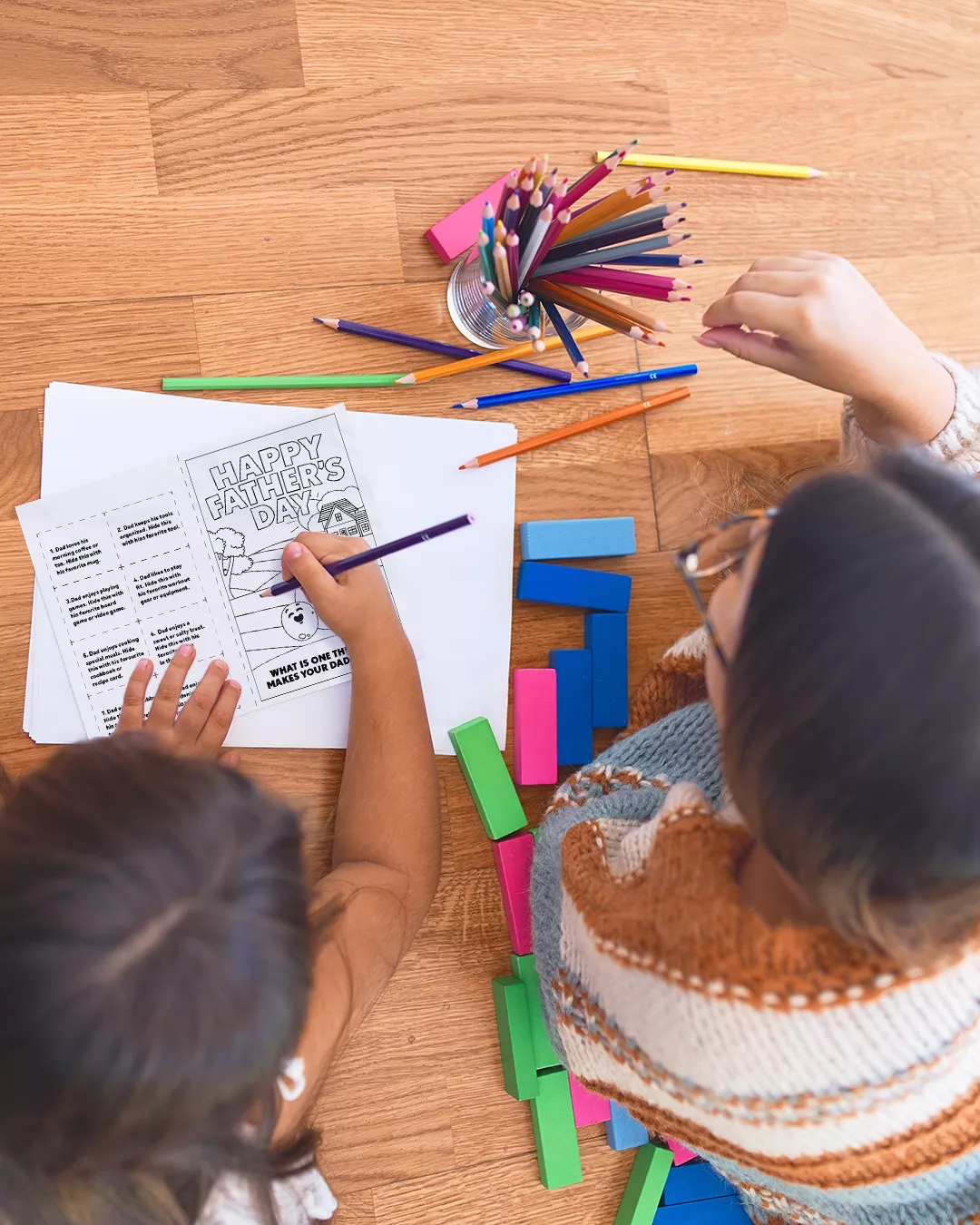 Children color a page together on a printable coloring page.
