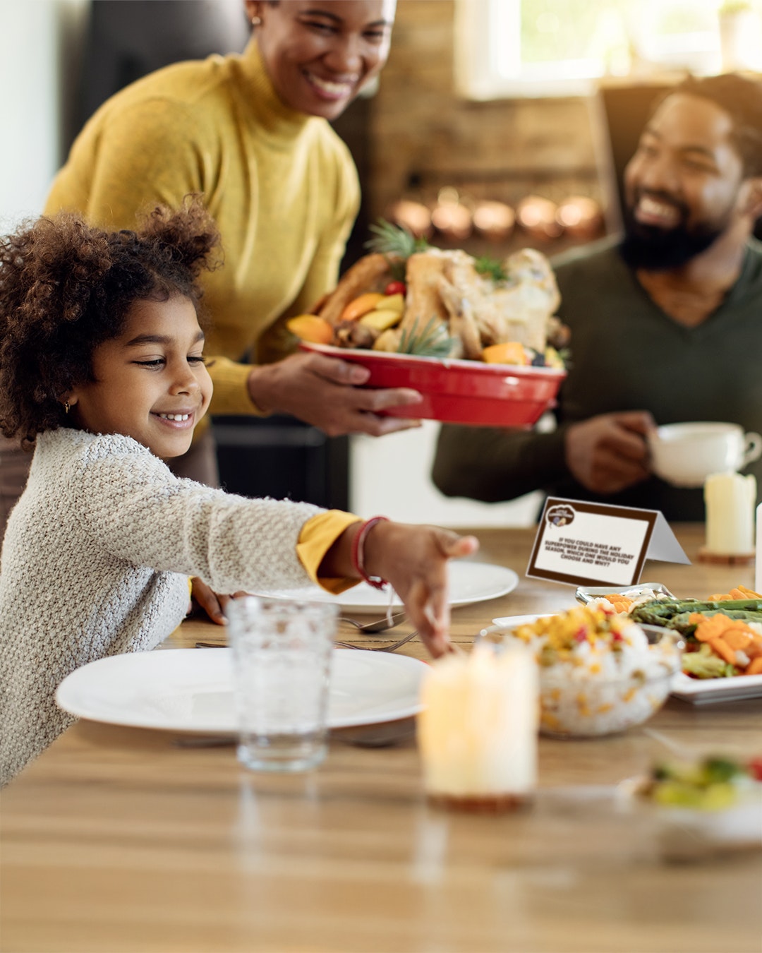 A family sitting around a holiday table getting ready to enjoy a meal.