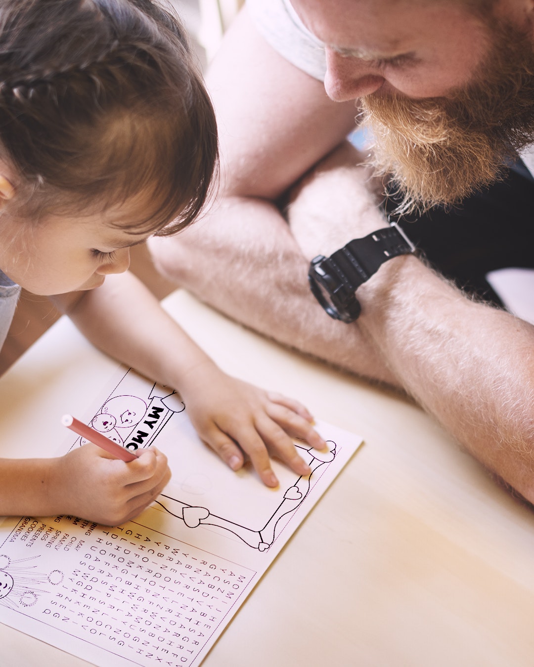 A parent and child color an activity booklet together for Mother's Day