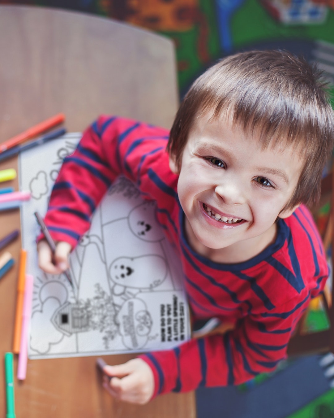 A child happily works on a coloring page.