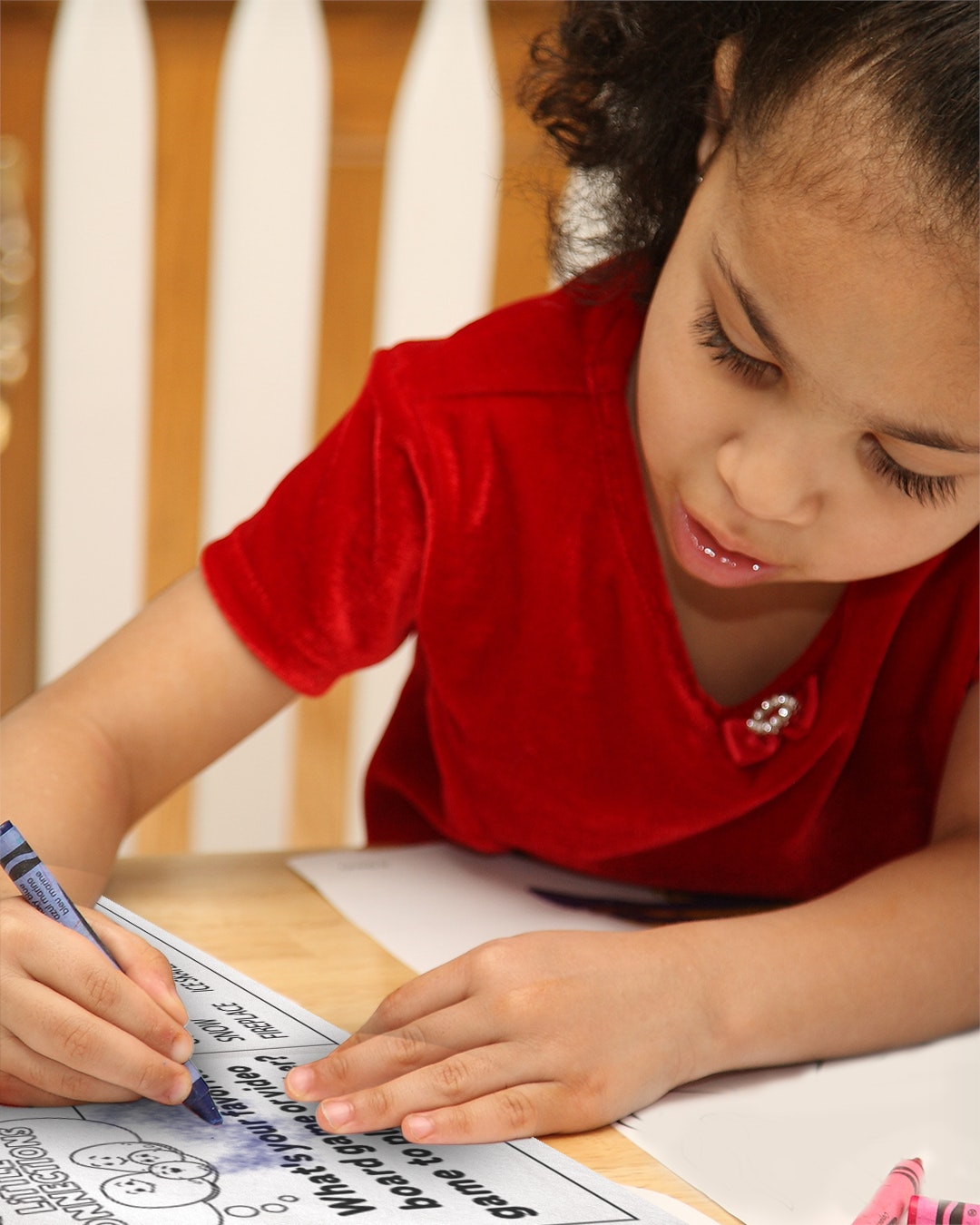 A child coloring a page in a book for the winter holidays.