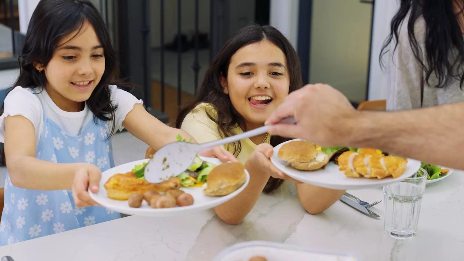 Two girls being served dinner