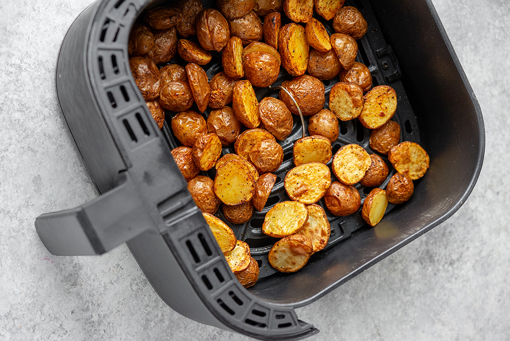 Crispy Little Potatoes inside the basket of an Air Fryer.