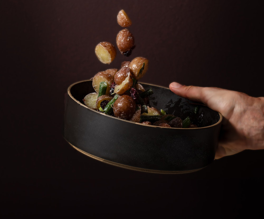 Little Reds™ getting tossed in a bowl against a brown background.