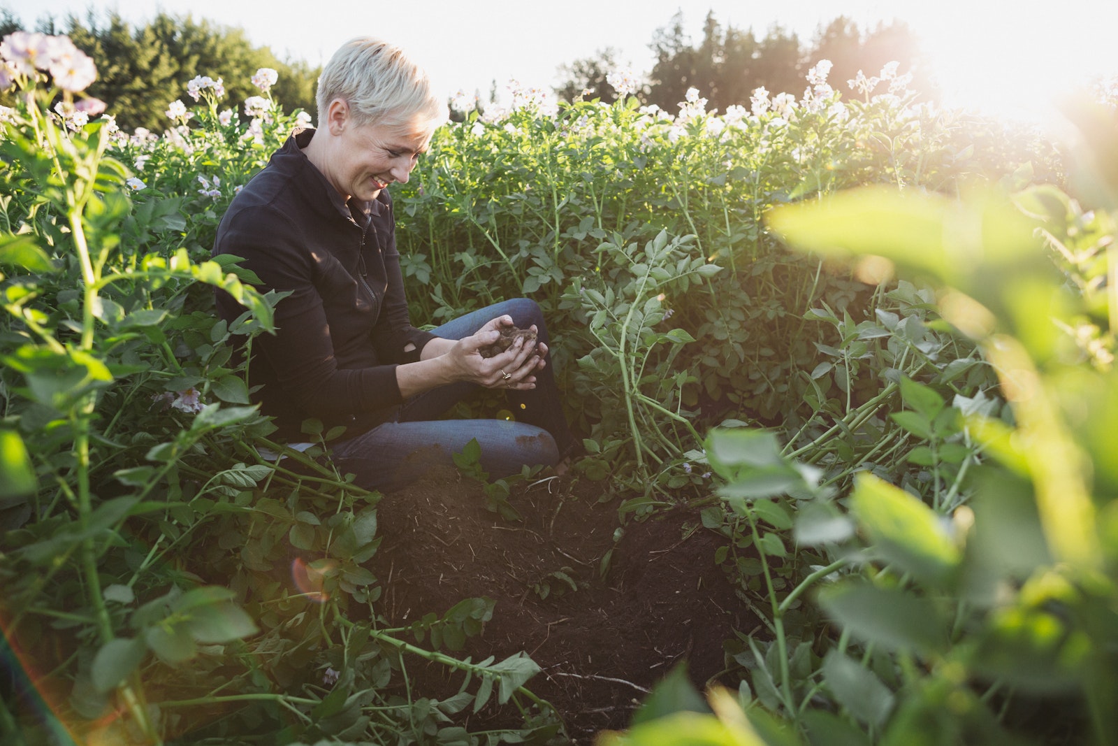 Angela Santiago, CEO and Co-Founder of The Little Potato Company, is in field surrounded by Little Potatoes.